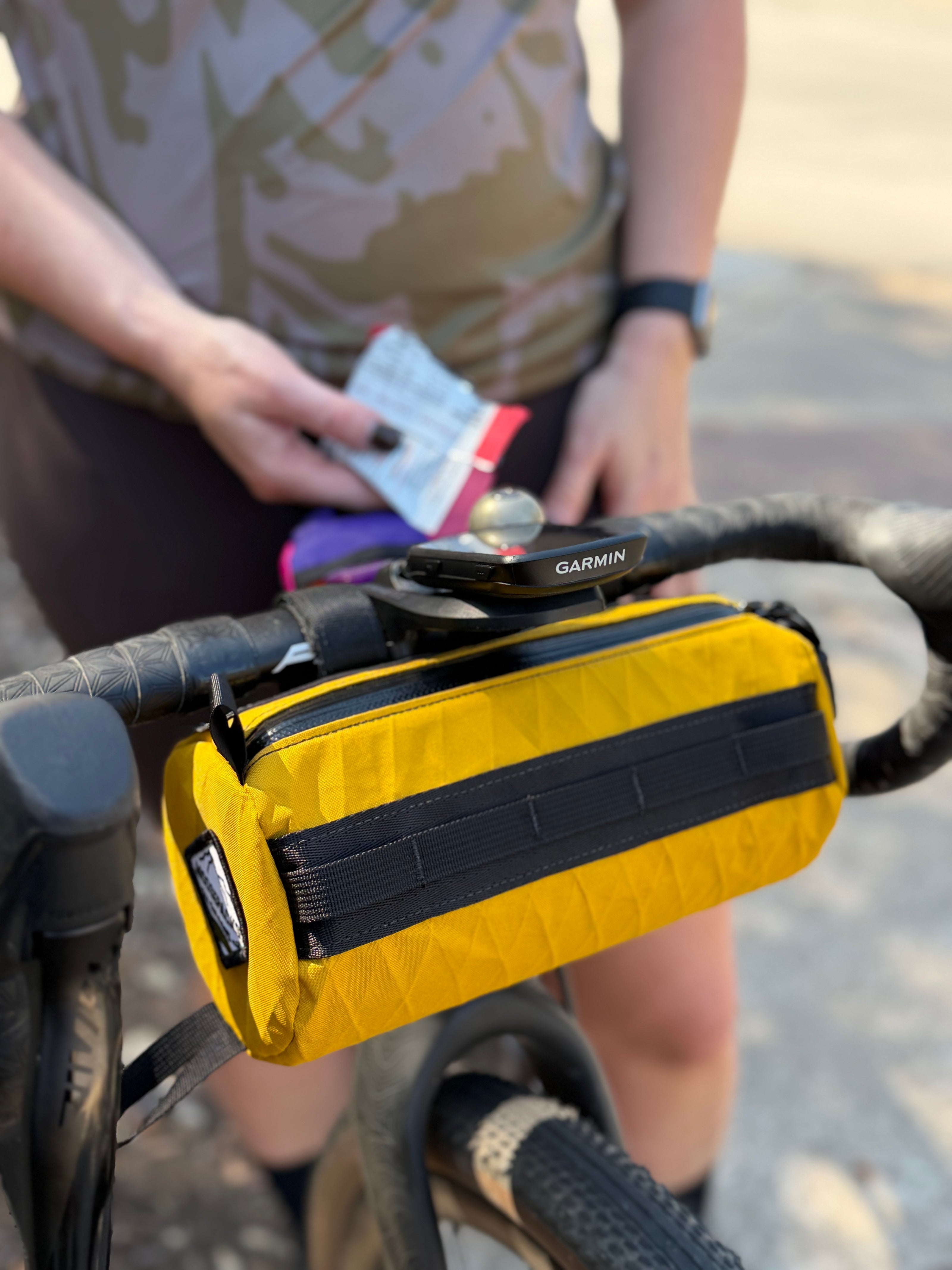 Yellow handlebar bag attached to gravel bike. 